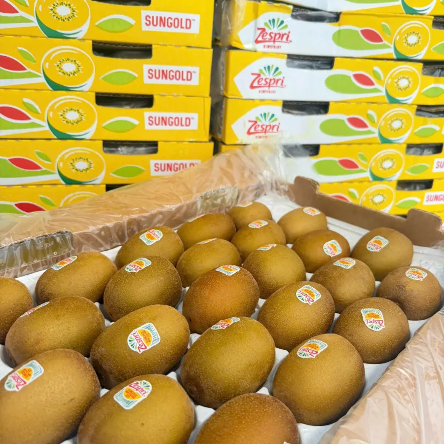 Kiwi Zespri xếp trong khay, phía sau là các thùng Zespri